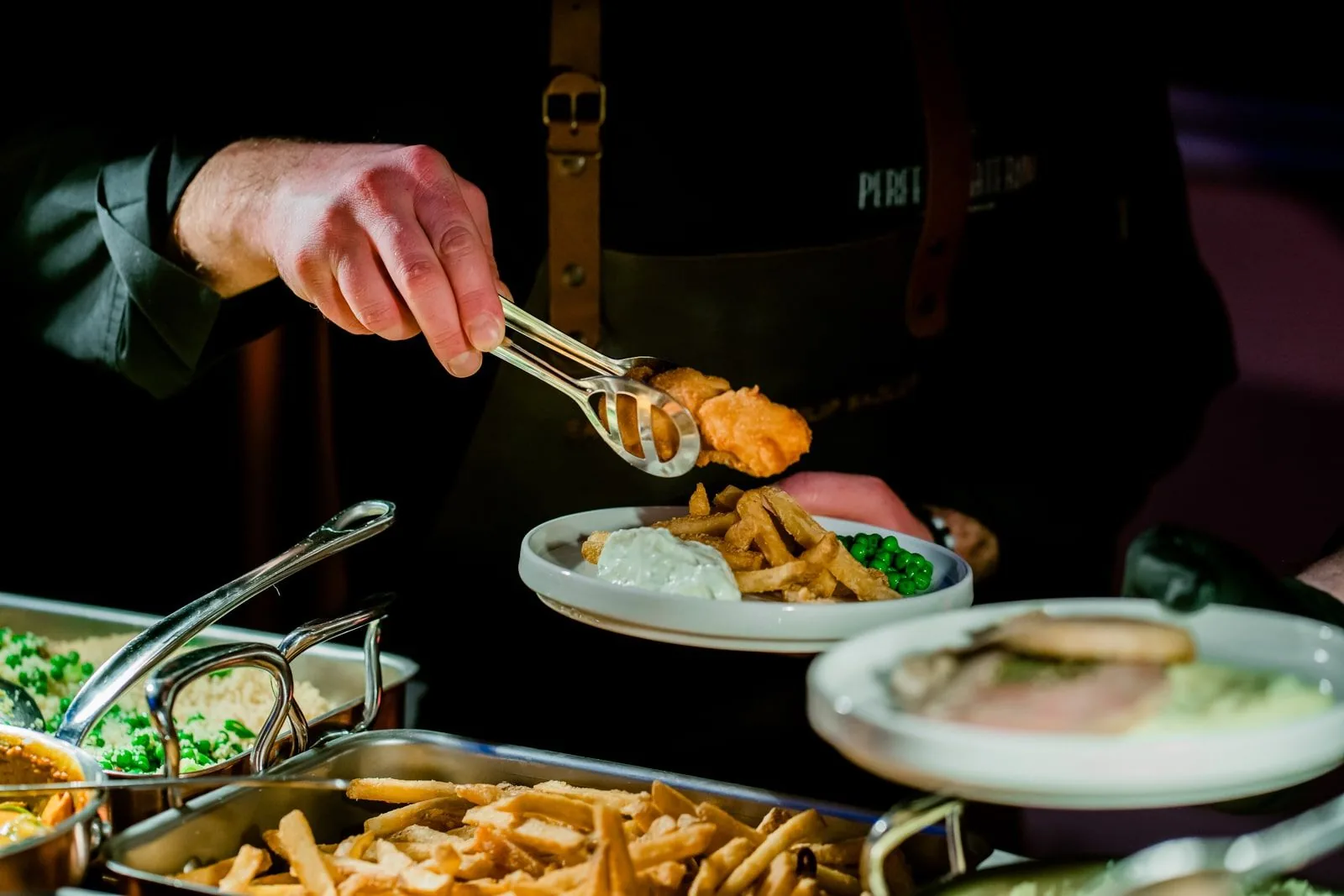 Chef finishing the plating of a hot course